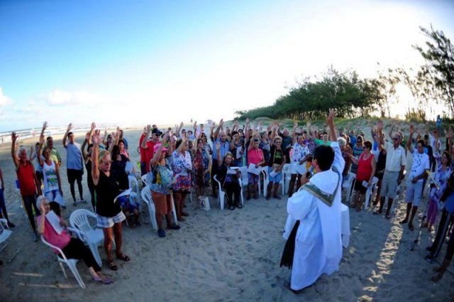 Na onda do papa Francisco: Padre celebra missa para fiéis que recém saíram do mar, ainda de roupa de banho, enrolados na toalha
